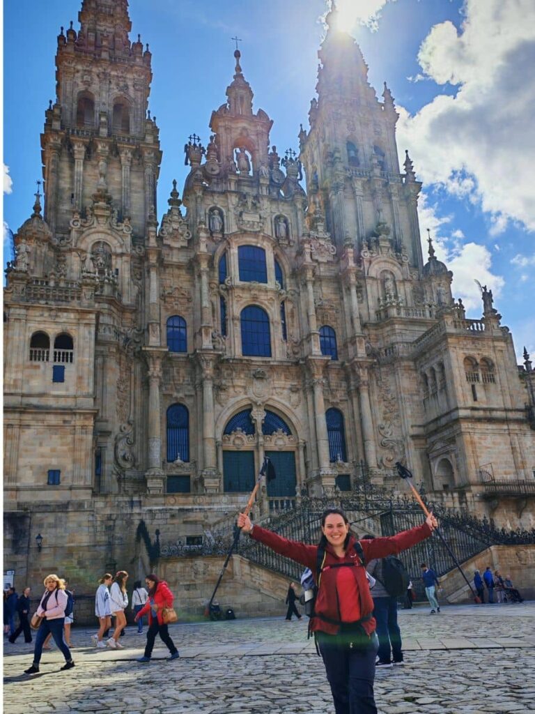 Pellegrina e travel designer davanti la cattedrale di Santiago di Compostela all'arrivo del Cammino di Santiago Francese